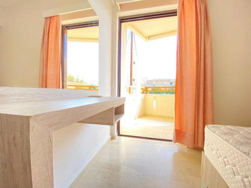 罗希姆诺Domenica Apartments的客房设有桌子和大窗户。