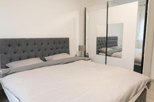 斯拉沃尼亚布罗德Apartman Škrinjar的卧室配有一张白色大床和镜子