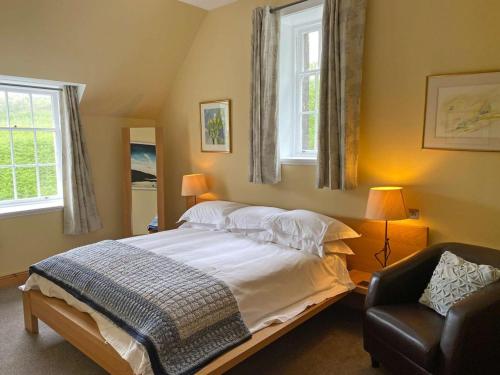 托伯莫里格伦格尔木城堡住宿加早餐旅馆的一间卧室配有一张床和一把椅子,还有两个窗户