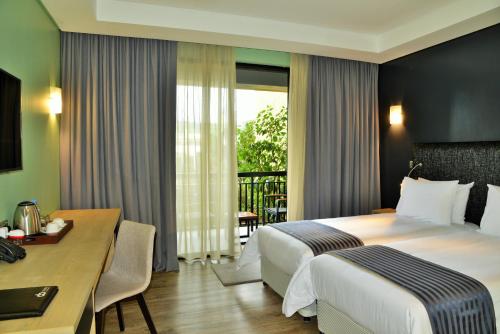 NyagatareEPIC Hotel & Suites的酒店客房配有一张床铺、一张桌子和一张书桌。
