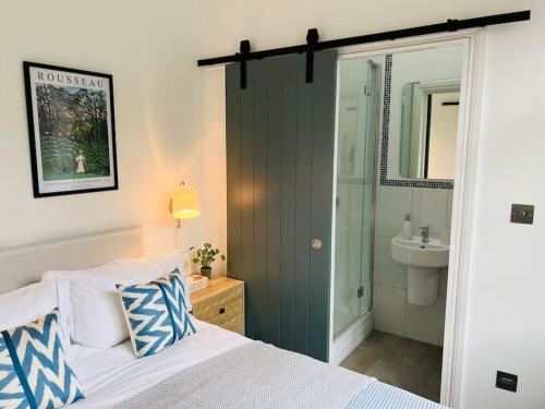 伦敦Forge Cottage - Pretty 1 Bedroom Cottage with Free Off Street Parking的一间卧室配有一张床、淋浴和盥洗盆