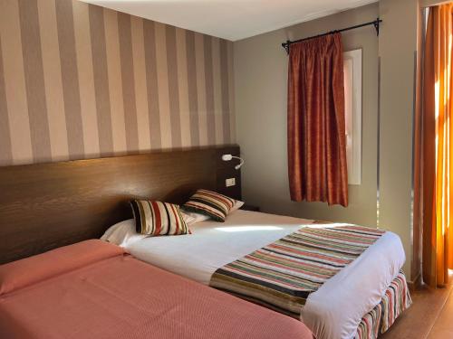 马德里劳斯考罗纳尔斯旅馆的酒店客房设有两张床和窗户。