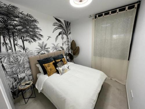 马尔德·克里斯塔尔Outstanding 2 bed apartment with rooftop sea views的卧室配有白色的床铺,墙上挂着植物