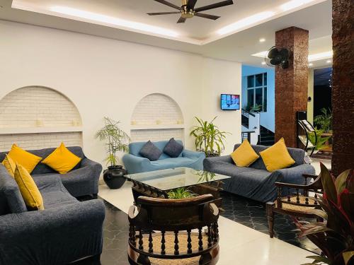 波尔沃林Otium Goa Resort by The Oterra的客厅配有蓝色沙发和黄色枕头。