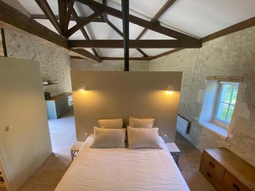 Bourg-CharenteBeautiful riverside boathouse的卧室配有一张白色大床
