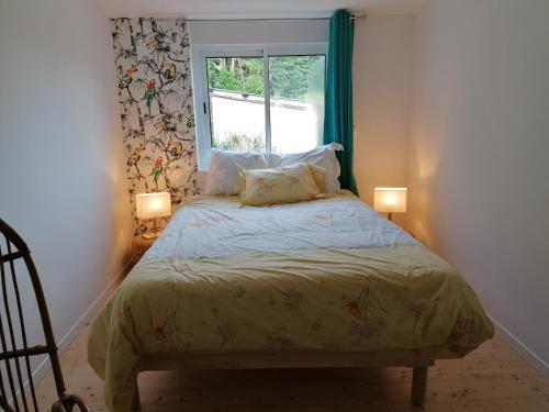 Angerville-lʼOrcherLa Polaris的一间卧室配有一张带两盏灯的床和一扇窗户。