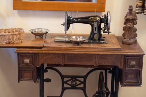 Kostitsiokakosolykos的木桌上的缝 ⁇ 机,上面有碗