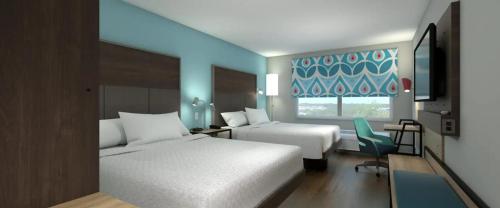 威尔明顿Tru By Hilton Wilmington的酒店客房设有两张床和窗户。