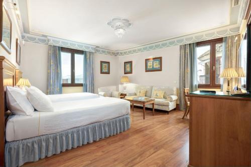 塞维利亚英伦酒店的一间带大床的卧室和一间客厅