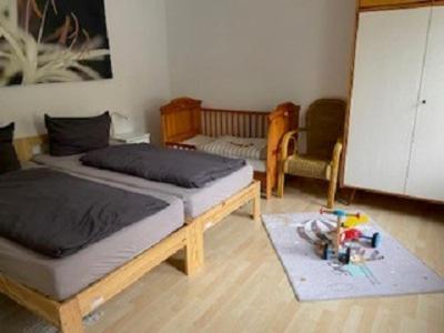 苏尔Ferienwohnung Am Rimbach的一间卧室配有两张床、一张桌子和一把椅子