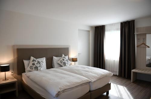 屈德勒凡Auberge de La Sauge的卧室设有一张白色大床和一扇窗户。