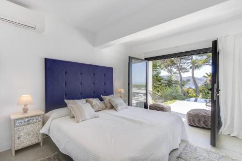 圣何塞德萨塔莱阿Magical Ibizan Villa Walking Distance To The Beach Es Vedre Style 6 Bedrooms Fabulous Sea Views San Jose的白色的卧室设有一张大床和一个大窗户