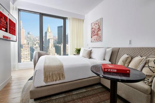 纽约Virgin Hotels New York City的一间卧室配有一张床、一张沙发和一个窗口