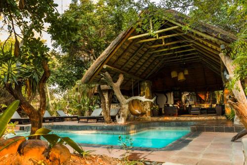 巴卢莱自然保护区恩祖韦尼野味旅舍的一个带游泳池和凉亭的度假村