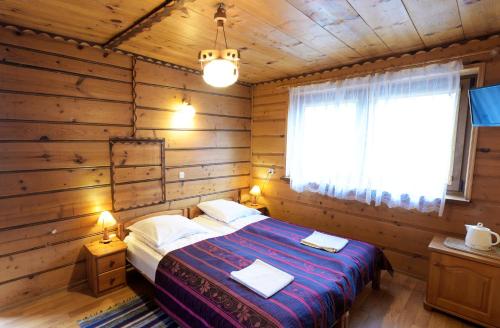斯洛莫夫采维日奈Agroturystyka Chmiel的小木屋内一间卧室,配有一张床