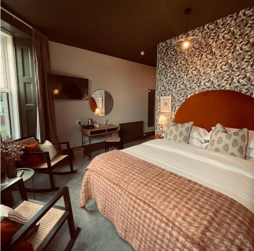 赫里福德皮尔格雷姆斯酒店的酒店客房设有一张大床和一张桌子。