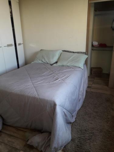 贝廷Aconchego do Roni e Patrícia的卧室配有一张带白色床单和枕头的大床。