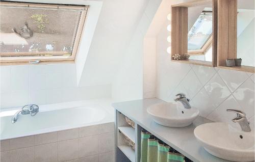 伊勒蒂迪潘阿豪瓦特骑士岛度假屋的浴室配有两个盥洗盆、浴缸和盥洗盆。