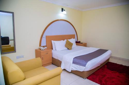 阿克拉禁区酒店的一间卧室配有一张床、一把椅子和一张沙发