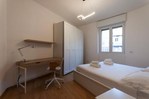 米兰YouHosty - Del Castagno 2的一间卧室配有一张床、一张书桌和一个窗户。