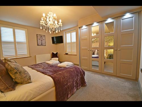 沃丁顿Luxury Waddington Cottage, Ribble Valley的一间卧室配有一张床和一个吊灯