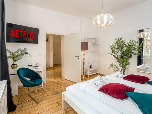 杜伊斯堡Fabelhafte Apartments zum wohlfühlen mit JUNIK Apartments的一间卧室配有两张床、一张桌子和一把椅子