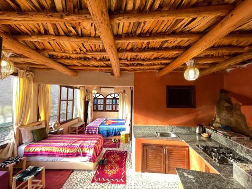 伊姆利尔Riad Atlas 4 seasons的一间带木制天花板的客厅和一间厨房