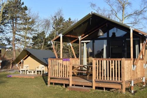 卡兰茨奥赫Safari Lodge, glamping aan zee!的小屋设有1个带大窗户的甲板