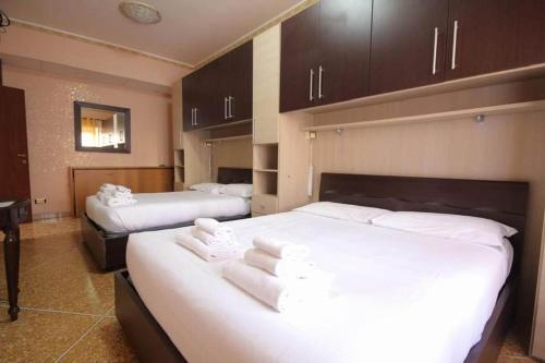 罗马海盗度假屋的酒店客房,配有两张带白色床单的床