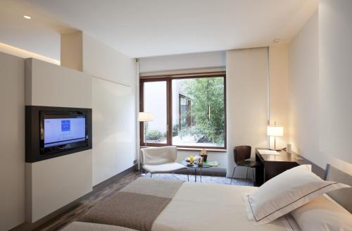 阿尔卡拉德荷那利斯阿尔卡拉赫纳雷斯汽车旅馆酒店的一间酒店客房,配有一张床和一台电视