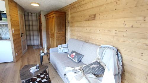 莱热L'OURALOU - Vue panoramique的带沙发和木墙的客厅