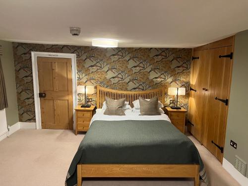 昂加穆尔贝利酒店的一间卧室配有一张床和两个带灯的床头柜