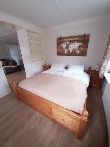 温特斯韦克B&B de Maalderi-je的卧室配有一张木床,墙上挂有地图