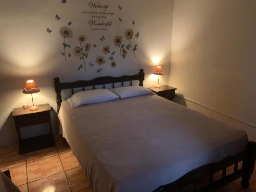 下博克特Linda Vista Cabins的卧室配有一张墙上鲜花的大床