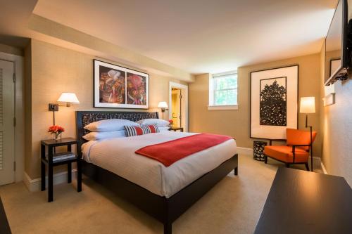 AuroraInns of Aurora Resort & Spa的配有一张床和一把椅子的酒店客房