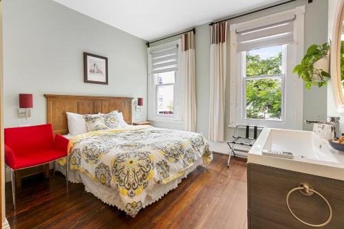 魁北克市塔林城堡酒庄酒店的一间卧室配有一张床和一张红色椅子