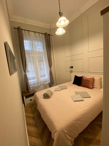 布达佩斯PJ apartment的卧室配有一张大白色床和窗户