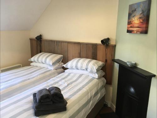 布雷肯Cosy Arts & Crafts Cottage with stunning views的一间卧室配有两张带白色枕头的床