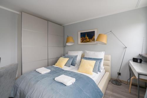 波兹南Apartament Turkusowa- z widokiem na korony drzew的一间卧室配有一张大床,提供黄色和蓝色的枕头