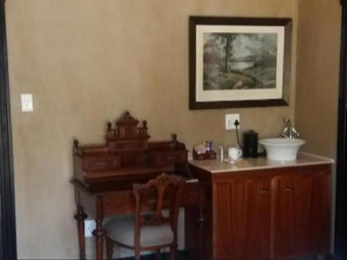 Dan PienaarSlot Loevenstein Guest House的一间带木制书桌和盥洗盆的浴室