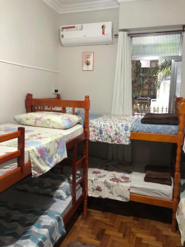 里约热内卢Guest House Copacabana Hostel的客房设有三张双层床和一扇窗户。