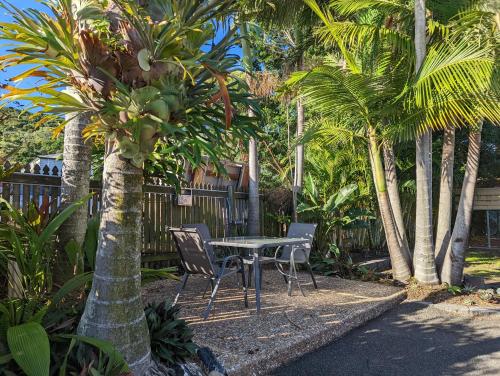 耶蓬风帆汽车旅馆的棕榈树花园内的桌椅