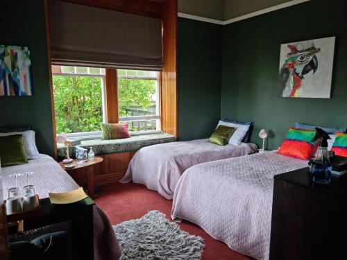 韦斯特波特Homestay On Queen的一间卧室设有两张床和窗户。