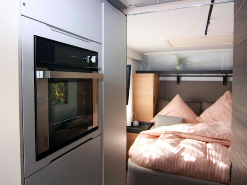 LütowDreamer luxury caravan on the backwaters, Lütow的一间小卧室,配有床和拖车内的电视