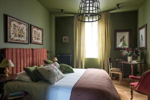 迪耶普La Villa Augustine的一间卧室设有一张带绿色墙壁和窗户的床。