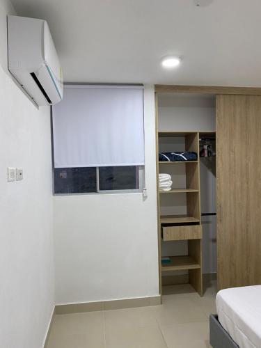 圣玛尔塔Apartment near to Bello Horizonte Beach, Santa Marta Airport的小房间设有窗户和一张床