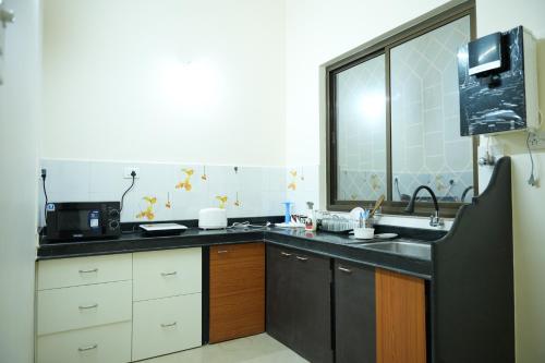 帕纳吉Shri Mahamaya的厨房配有水槽和微波炉