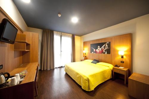 帕尔马帕尔马斯卡尼尼宜必思尚品酒店的酒店客房设有一张黄色的床和一台电视。