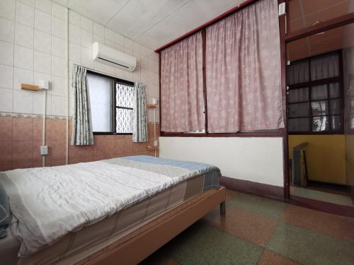 台南好南人-台南 雙人套房的一间卧室设有一张床和两个窗户。