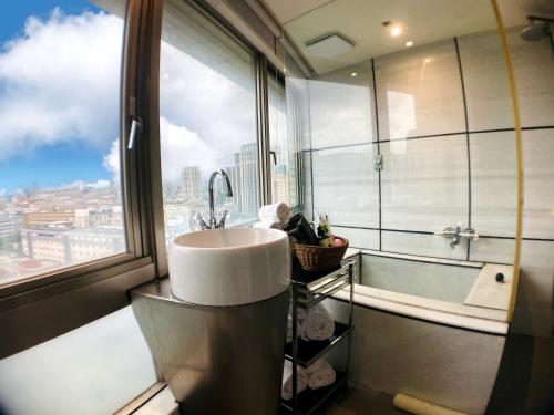 台北宝格利时尚旅馆的一间带水槽和浴缸的浴室以及窗户。